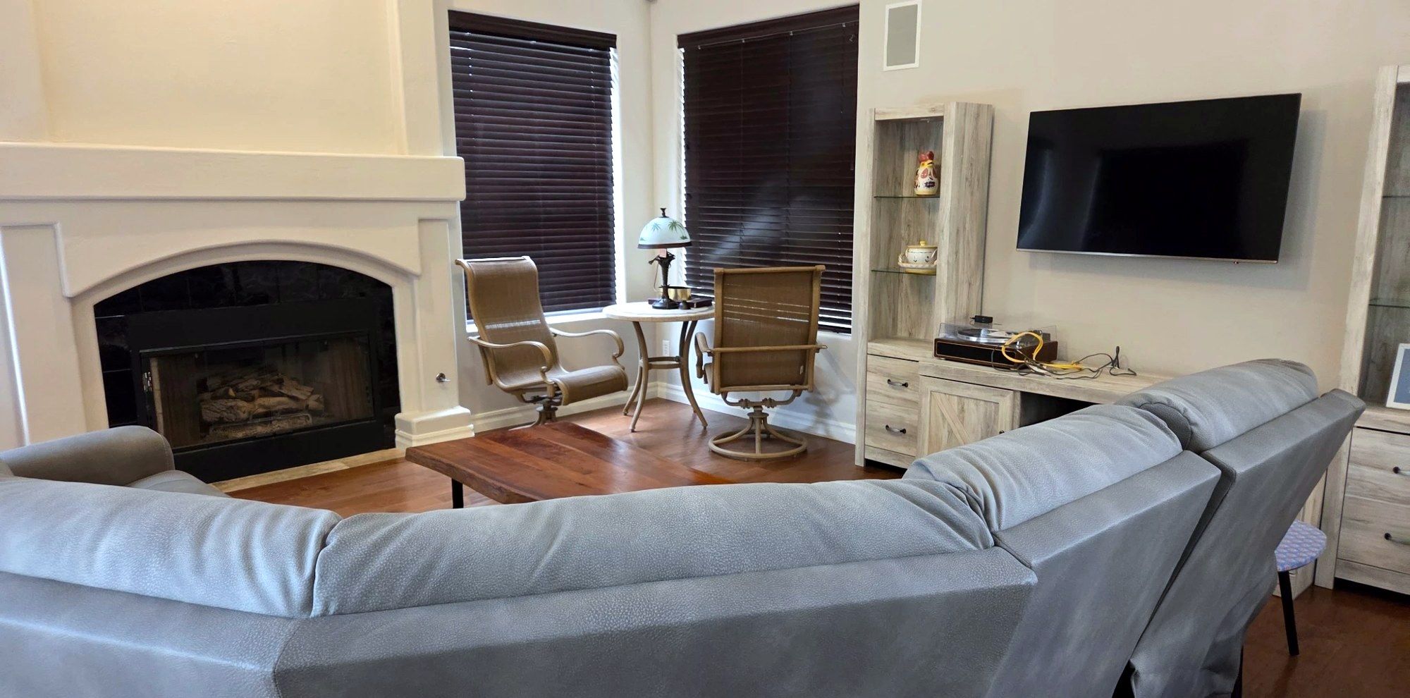 Living room with a fireplace and gray sectional after a Zita cleaning