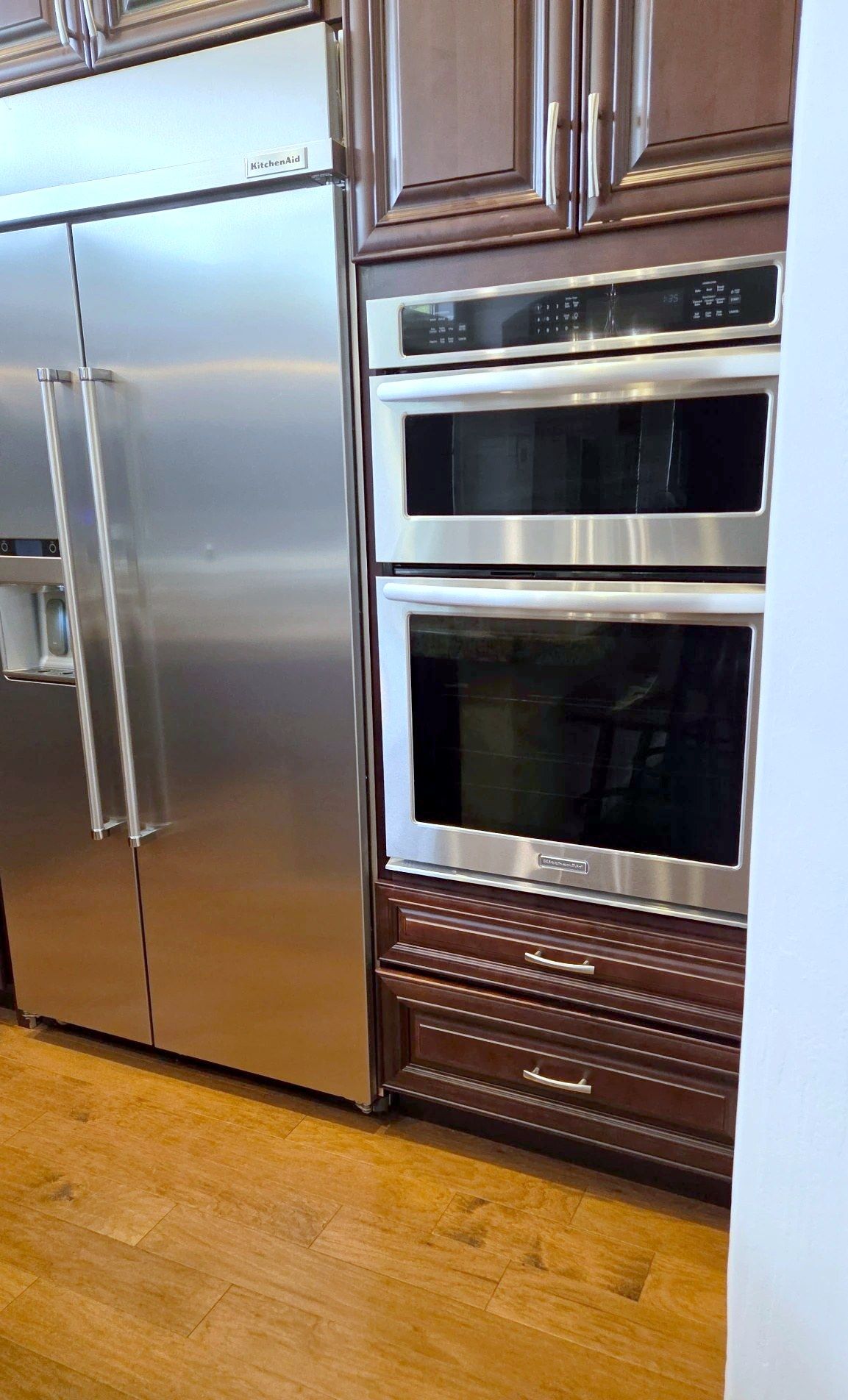 Kitchen with stainless refrigerator and double wall ovens, cleaned