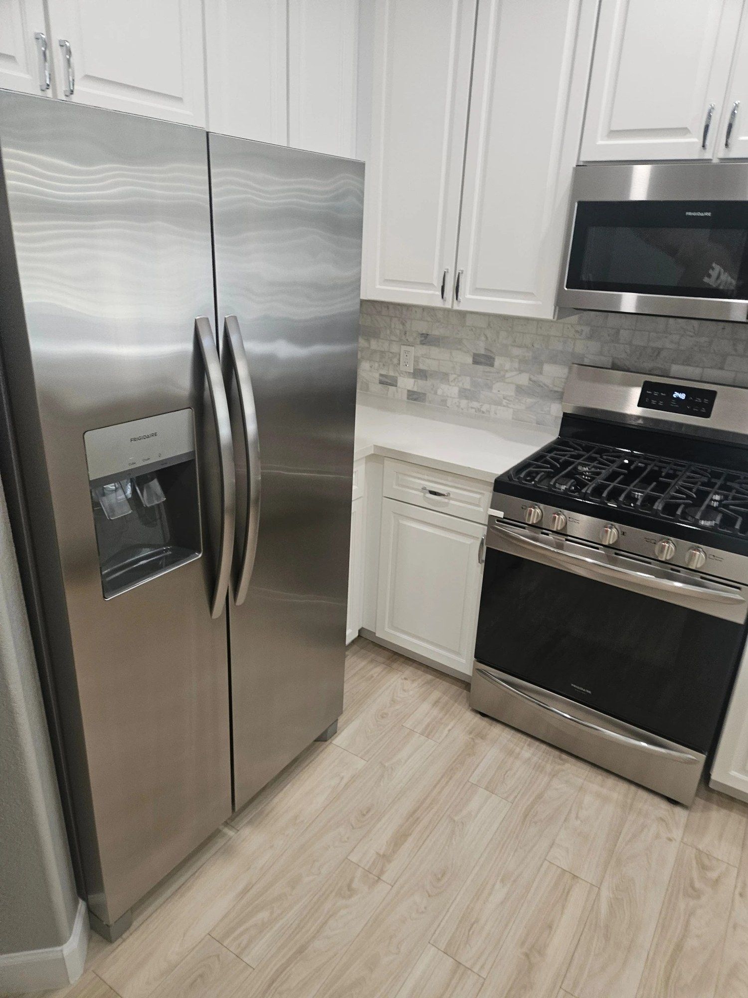 Empty kitchen with stainless refrigerator and range after a move-in clean
